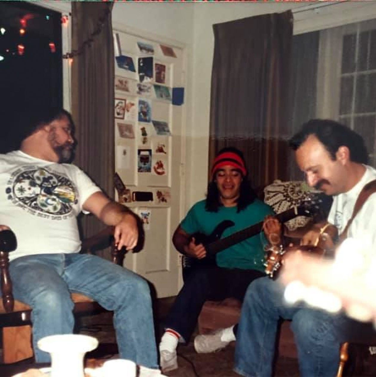 Three people playing music in a living room